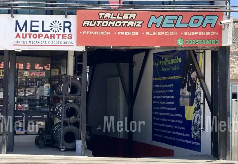 Entrada del taller automotriz Melor, con el rótulo rojo de afinación, frenos, alineación y suspensión y la lona de preverificación responsable